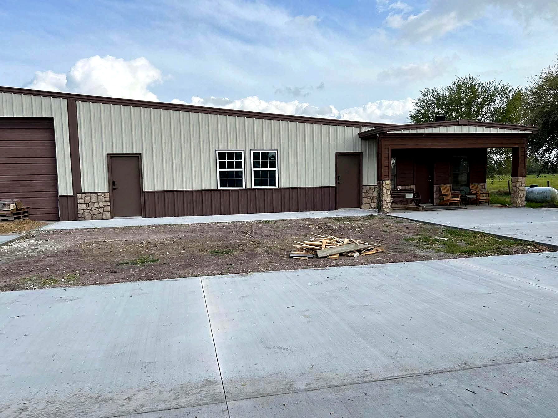 Finished steel building with metal siding and covered entry in rural Texas